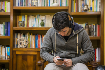 Young man sitting listening to music on headphones