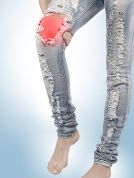 Female having sprain problems, holding her painful leg.