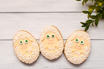 Easter cookies with myrtle and sheep on grey background