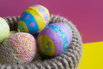 Multi-colored Easter eggs in knitted basket