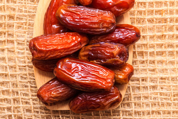 dried dates on wooden spoon cloth background