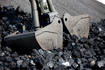 Coal loading excavator, heaps of coal