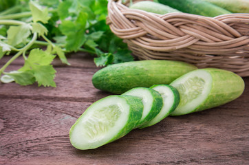Fresh cucumber and slices on wooden table