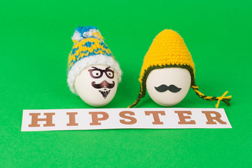 Hipster styled Easter eggs with funny knitted hats