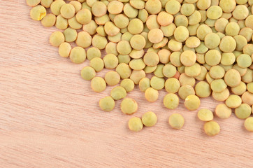 Close up of green lentil on wooden background