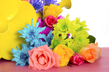 Colorful Spring roses and daisy flowers on pink wood table.