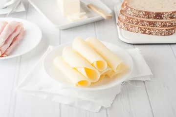 Fototapeten cheese rolled up on white plate © zoeytoja