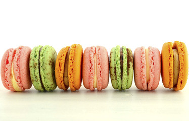 Colorful macaroons on white wood table.