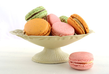 Colorful macaroons on white wood table.