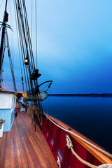 Sailboat at dawn with deep blue light. At sea.