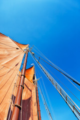 Tall ship at sea, looking up at the sails in the wind