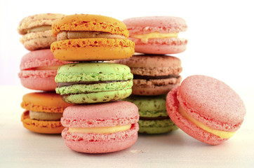 Colorful macaroons on white wood table.