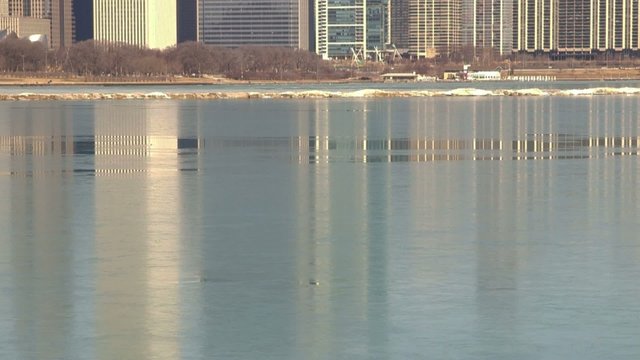 Chicago, Illinois skyline reflecting on Lake Michigan icy water