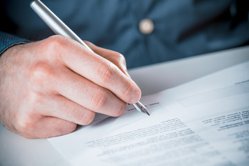 Man signing a document with a fountain pen