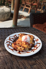 Banana desert with ice cream in seaside cafe