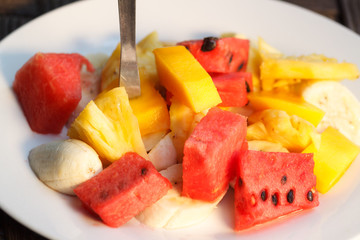 Mix of different fruit salad on white plate