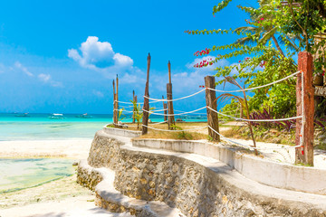 tropical beach with palm trees and beach beds, summer vacations
