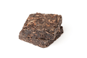 Two small briquette of Chinese Pu-erh tea isolated on white