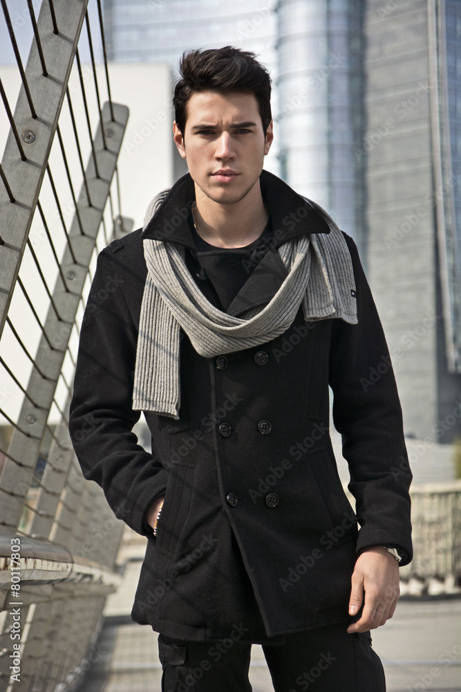 Wall mural Stylish Young Man in Black Coat Standing in City Center Street