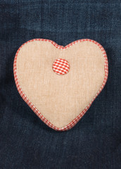 Fabric handmade heart on a blue denim jeans background