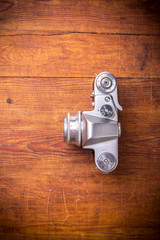 Vintage photo camera on a wooden background, top view