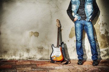 leaning on the wall with an electric guitar