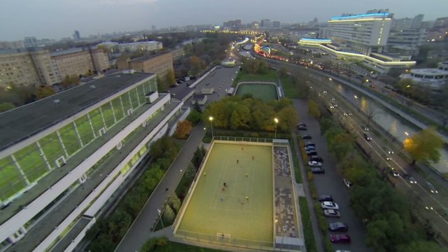Traffic on quay of river near soccer field of sports complex