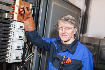 Electrical service worker turning on main switcher in box