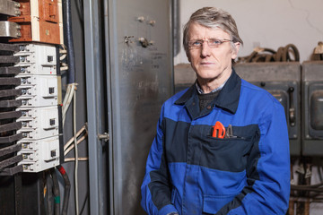 Electrician worker standing near high voltage panel