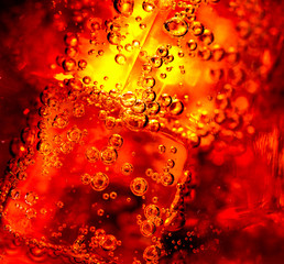 Cola background. Cola with Ice and bubbles in glass closeup