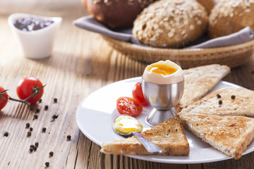 Soft-boiled egg in the morning with pepper, tomatoes and crouton