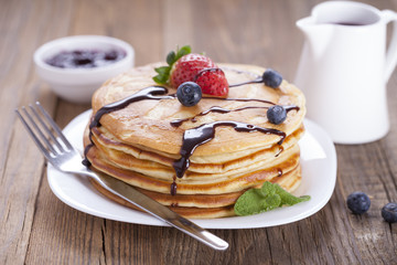 Delicious sweet American pancakes on a plate with fresh fruits