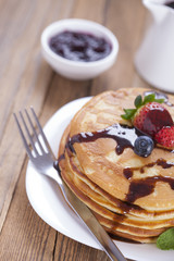 Delicious sweet American pancakes on a plate with fresh fruits