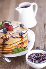 Delicious sweet American pancakes on a plate with fresh fruits