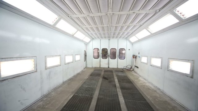Metal paint-spraying booth with many lights for cars