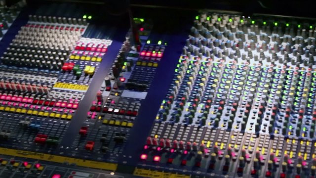 Professional audio mixer runs with illumination and many knobs