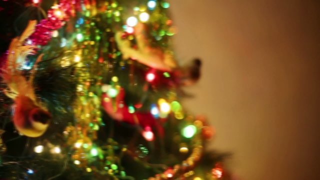 Decorating Christmas tree with toys bird and garlands at evening
