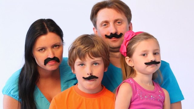 portrait of father, mother, daughter and son with false moustaches at all close up