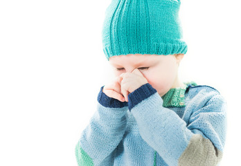 crying little boy wiping tears from face