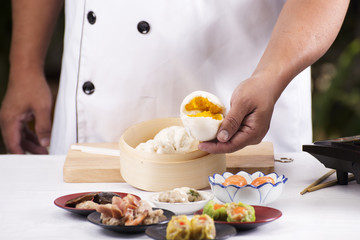 Obraz na płótnie Canvas Hand of chefd holding steamed dumpling bun