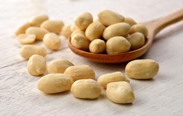peanut in the spoon on white wooden