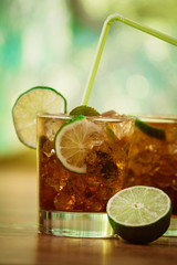 drink concept - cocktail with cola ice cubes and lime