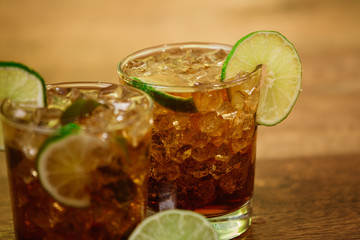 drink concept - cocktail with cola ice cubes and lime