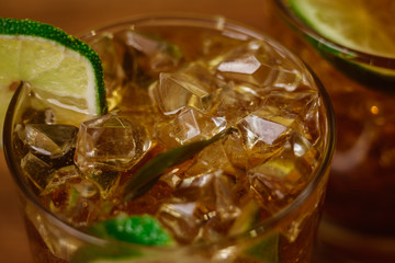 drink concept - cocktail with cola ice cubes and lime
