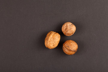 three walnuts on black paper