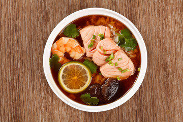 Asian soup with seafood, salmon, shrimp, lemon, mushrooms and ri