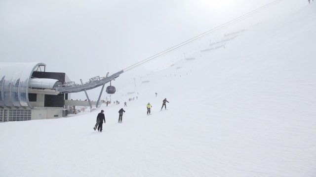 Skiers go to ski route near ropeway station