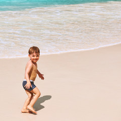 Two year old boy playing on beach