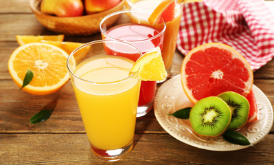 Fresh juices with fruits on wooden table