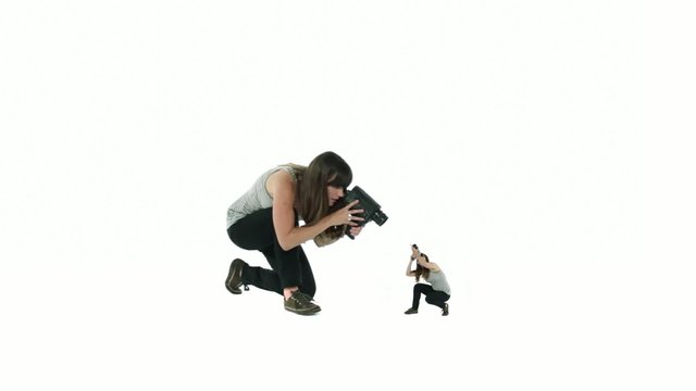 Woman films a smaller version of herself, who in turn films her larger twin.  Self-reflection, introspection, narcissism and self-analysis.